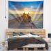 Designart 'Huge Wooden Pier into Setting Sun' Pier Seascape Wall Tapestry
