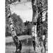 Vintage photograph of boy and girl fly-fishing as seen from between beech trees Poster Print (24 x 36)