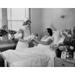 Female nurse giving a newborn baby to a young woman lying in a hospital bed Poster Print (24 x 36)