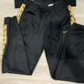 Nike Pants & Jumpsuits | Nike Black Track Pants With Gold Swish & Side Seam Ornamentation | Color: Black/Gold | Size: M