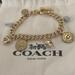 Coach Jewelry | Coach Gold Charm Bracelet With 7 Charms, Toggle Closure. | Color: Gold/Silver | Size: Os