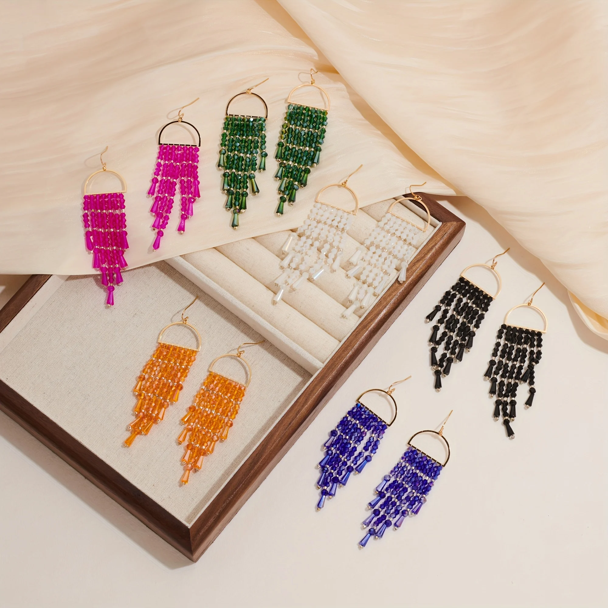 Die Kombination aus modernen und hochwertigen farbigen Kristallen, Reisperlen, Quastenohrringen, Metall und Perlendesign Image