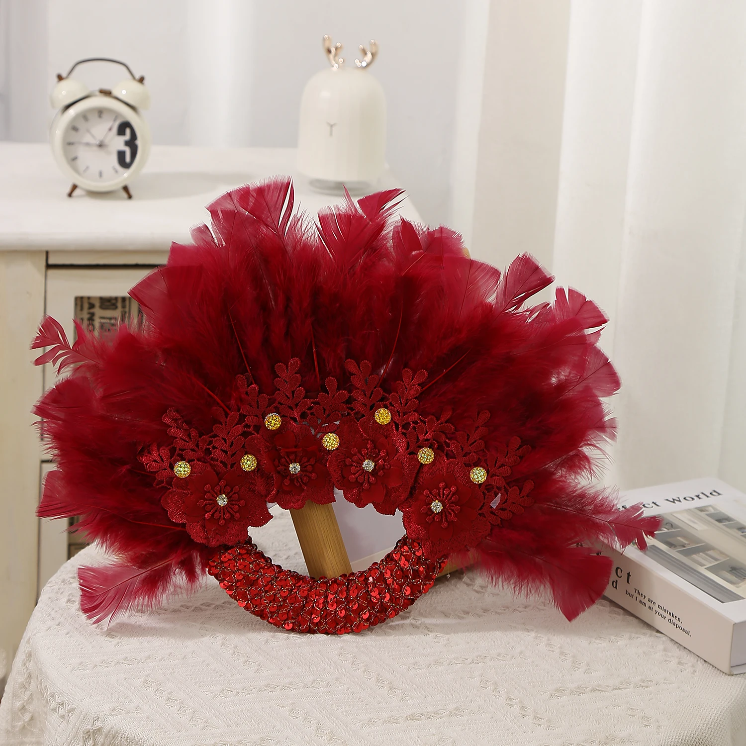 Elegante Braut hält Federfächer, Blumenrosen aus Kunsthandwerk, Foto-Requisiten, Hochzeitsdekorationen Image