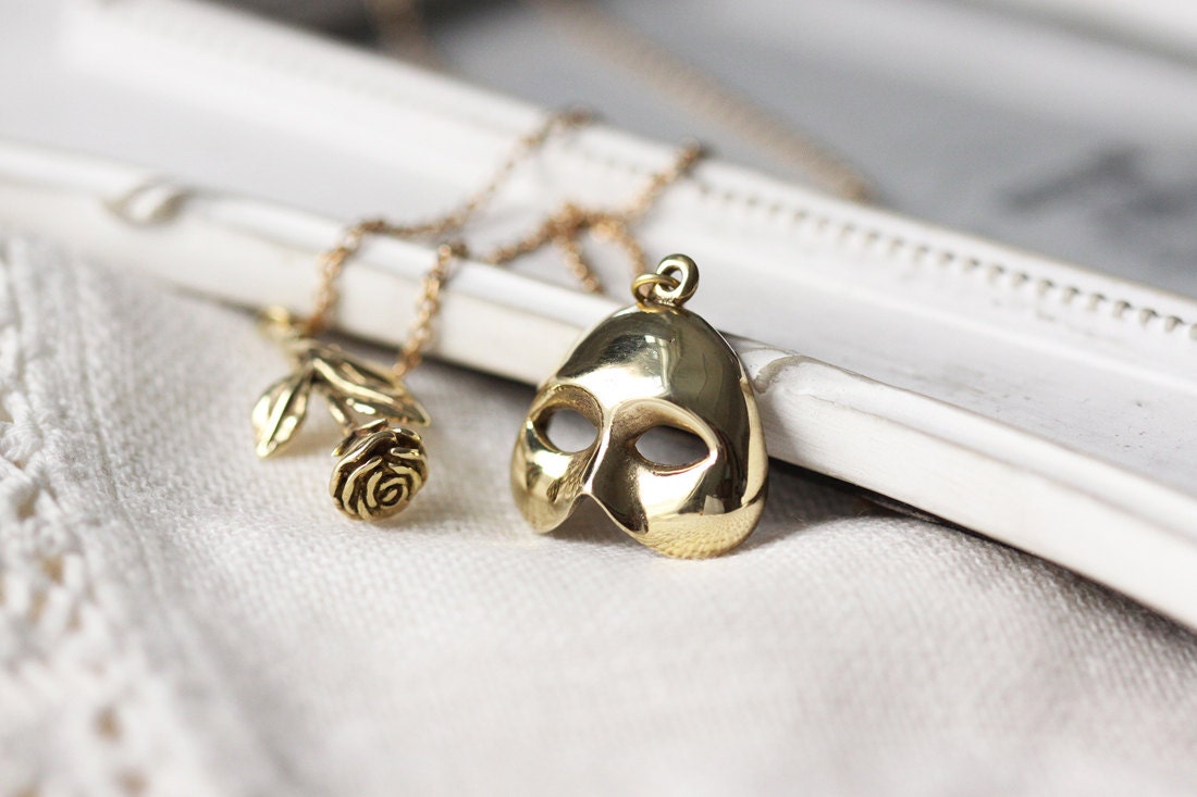 collana in oro con rosa e maschera, mezza maschera con ciondolo rosa, maschera dorata con collana rosa, collana con ciondolo maschera e rosa, piccola