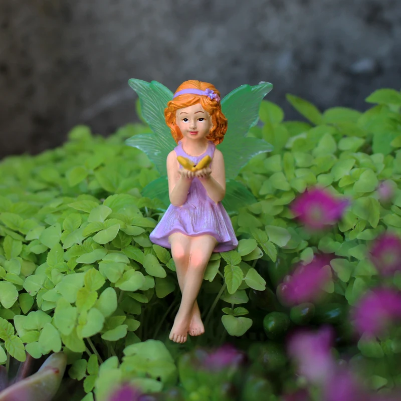 Eine Schmetterlingsblumenfee hält, geeignet zum Dekorieren von Gärten, Rasen und Blumentöpfen als Valentinstagsgeschenk Image