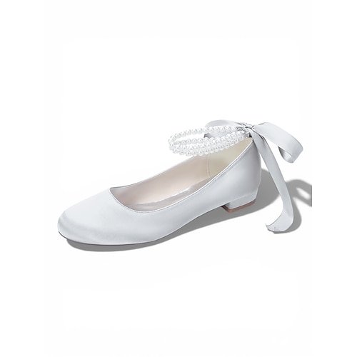 Elfenbeinfarbene, perlenbesetzte Ballerinas mit Knöchelriemen für Damen, elegante Brautschuhe im Ballerina-Stil für eine Hochzeit im Freien auf dem Rasen Image