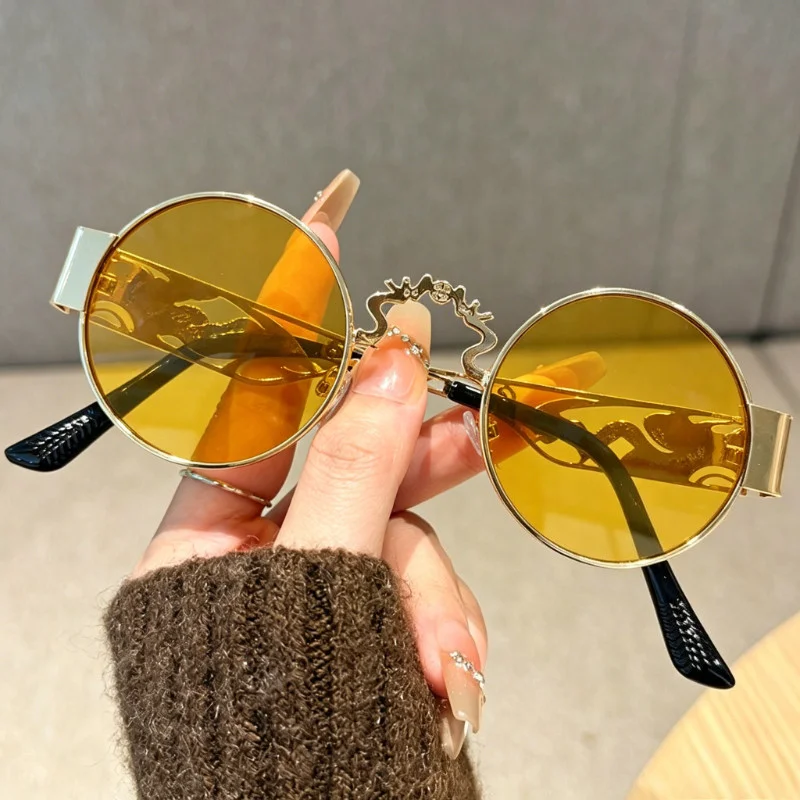 Exquisite Retro-Brille mit runden, ausgehöhlten Gläsern und einem goldenen Punk-Metallrahmen. Image