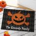 The Holiday Aisle® Almanzar Jack O Lantern & Crossbones Personalized 18 in. x 27 in. Non-Slip Outdoor Door Mat Synthetics | Wayfair